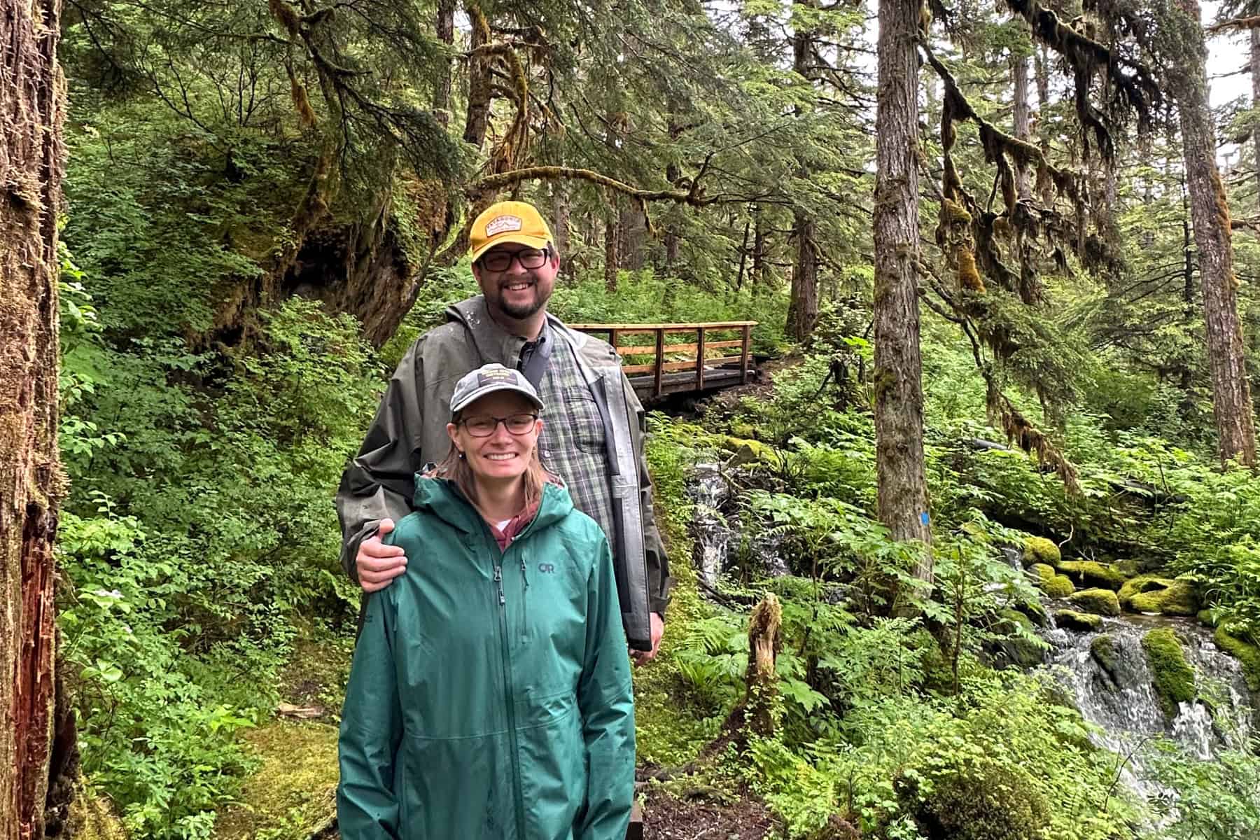 Visitors walking on a wooden boardwalk trail through Southeast Alaska rainforest