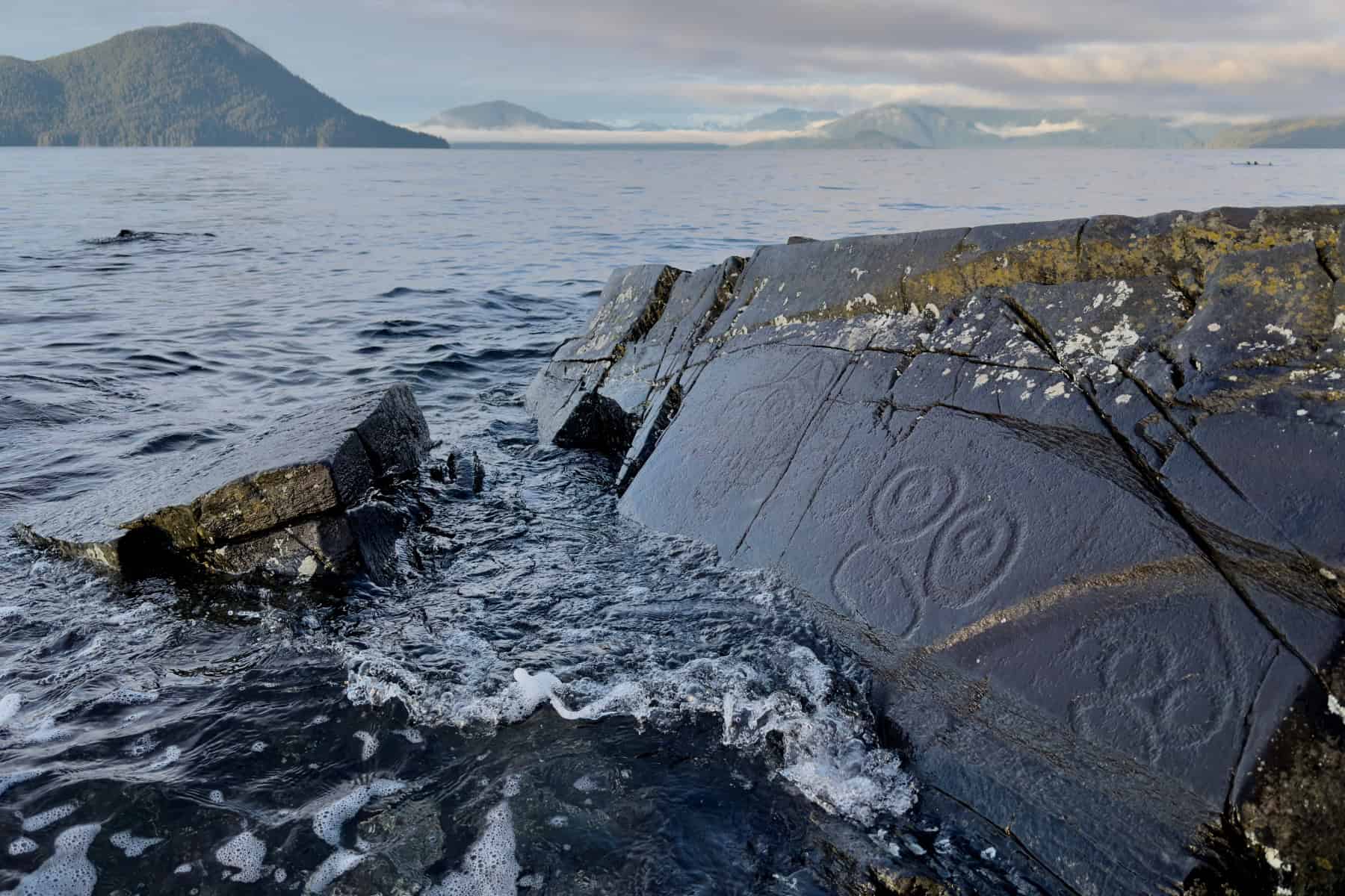 Ancient Tlingit petroglyphs carved into beach rocks in Wrangell, Alaska