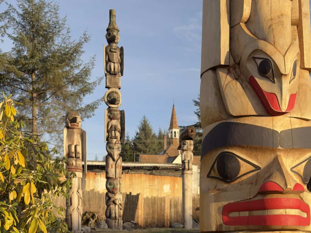Totem poles at Kiks.ádi Totem Park in Wrangell, Alaska, shown in warm evening light.